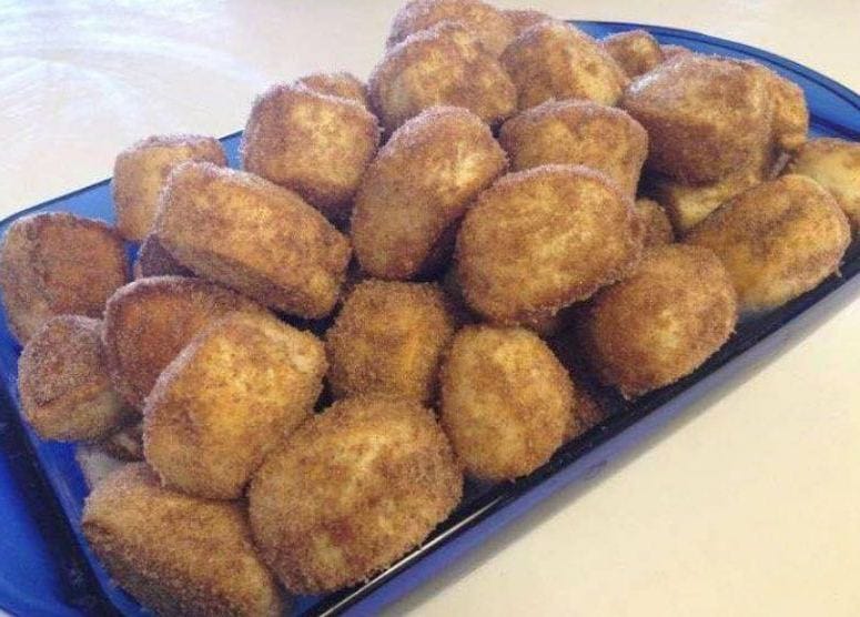 Close-up of freshly baked cinnamon bites on a white plate.
