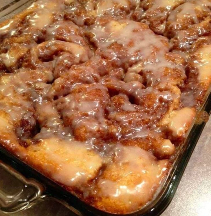 Cinna-Bun Cake displayed on a white plate, topped with a generous layer of cinnamon-infused goodness.