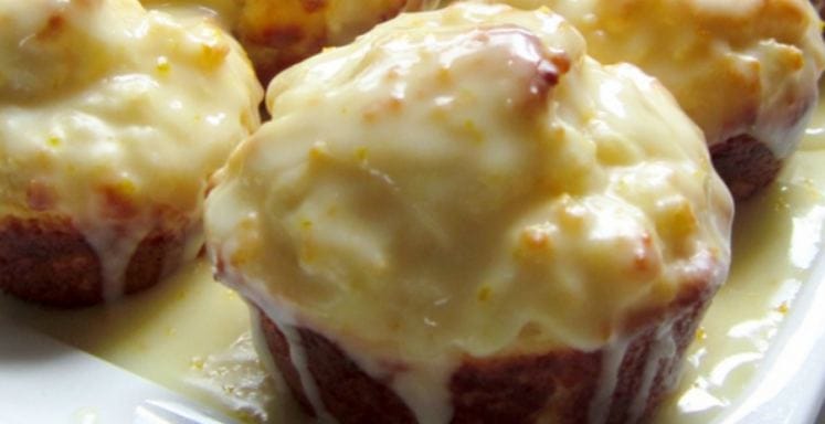 Close-up of freshly baked double-dipped orange muffins on a wire rack.