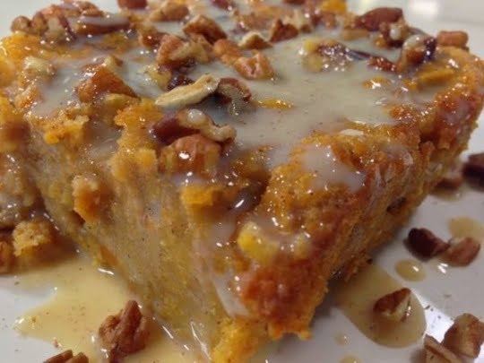 A photo of a slice of bread pudding with vanilla sauce drizzled on top