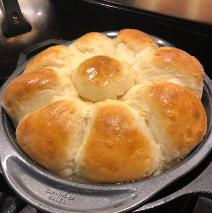 A golden brown basket overflowing with soft and buttery homemade yeast rolls.