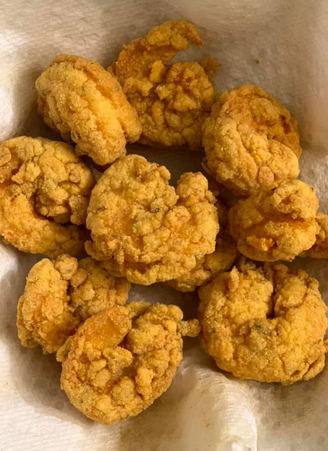 A plate of perfectly fried shrimp, golden-brown and crispy