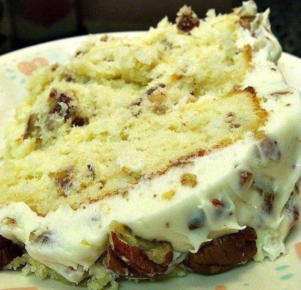 "Quick Italian Cream Cake: A slice of moist perfection topped with toasted coconut and pecans, crafted for indulgence."