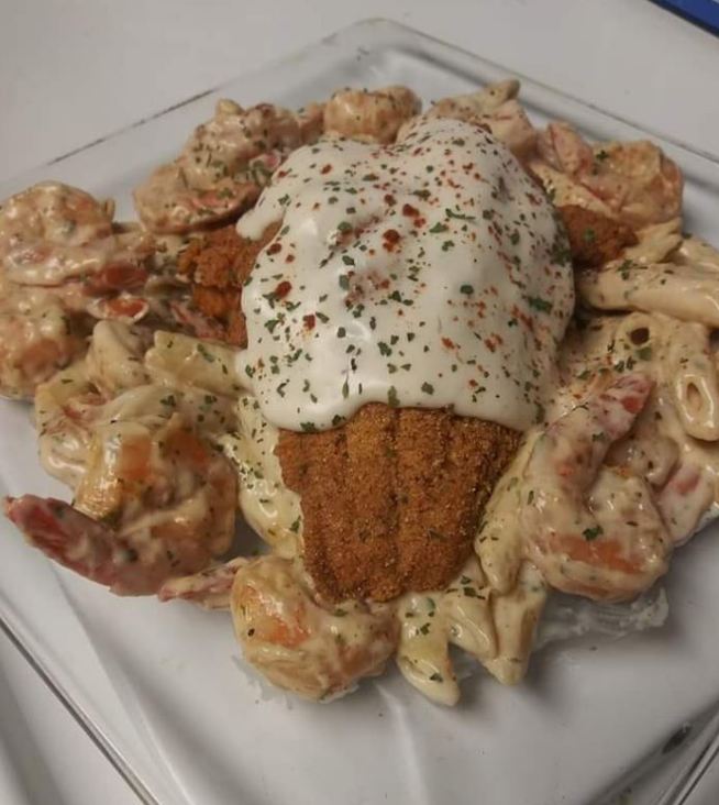 A bubbling hot casserole dish filled with tender catfish, plump shrimp, and cavatappi pasta in a creamy white alfredo sauce.