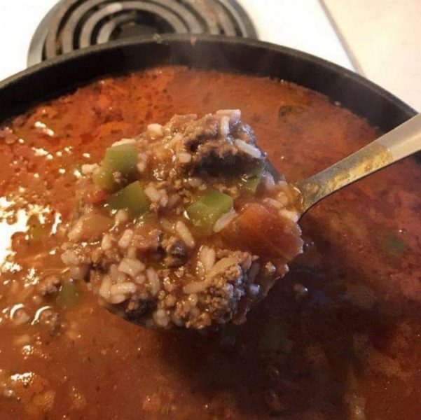 A bowl of homemade Stuffed Pepper Soup topped with fresh herbs and served with crusty bread.