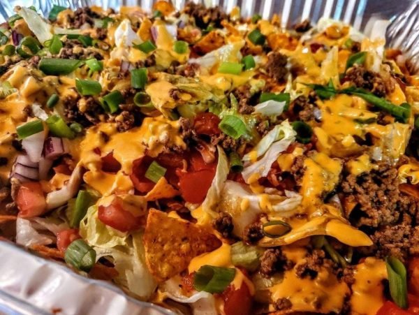 "Doritos Taco Salad: Fresh lettuce, tomatoes, cheese, and seasoned meat topped with crunchy Doritos.