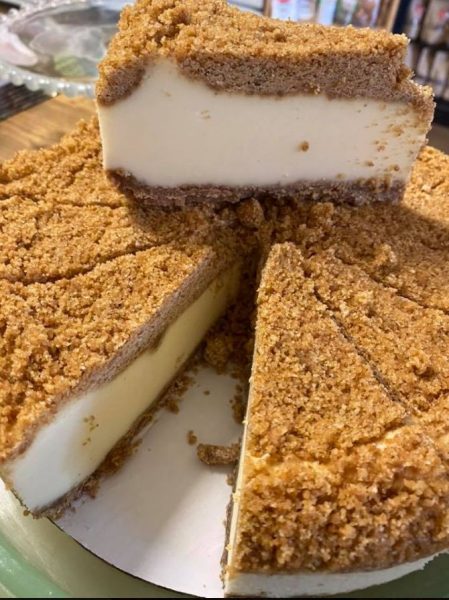 A slice of Double-Crust No-Bake Cheesecake on a plate with crumbs on the side