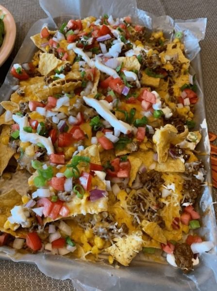 Epic Beef Nachos Supreme: A delicious platter of nachos topped with seasoned ground beef, melted cheese, diced tomatoes, and green onions.