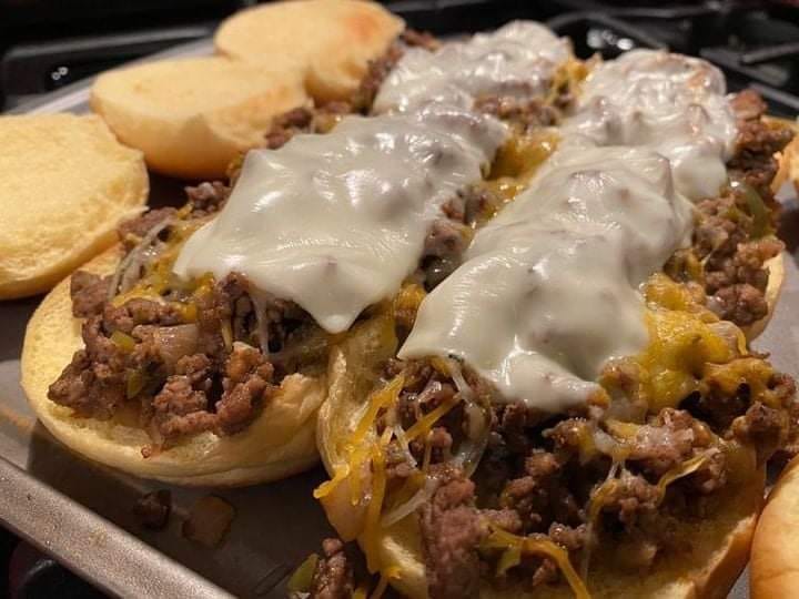 A delicious Philly Cheese Steak Sandwich with thinly sliced beef, melted cheese, and sautéed onions and peppers on a toasted roll.