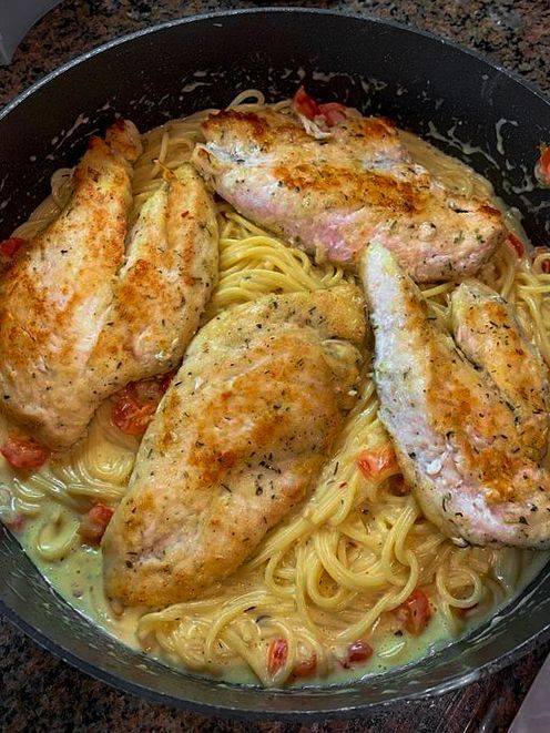 Italian Chicken Pasta: Juicy chicken, al dente spaghetti, and creamy Parmesan sauce on a white plate.