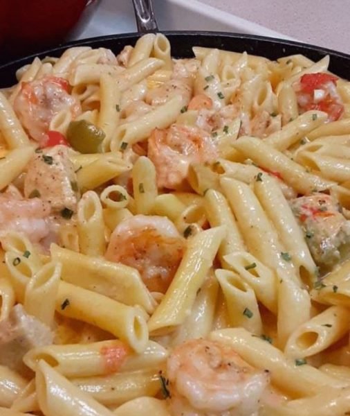 Cajun shrimp and chicken pasta in a white cream sauce with pasta and vegetables