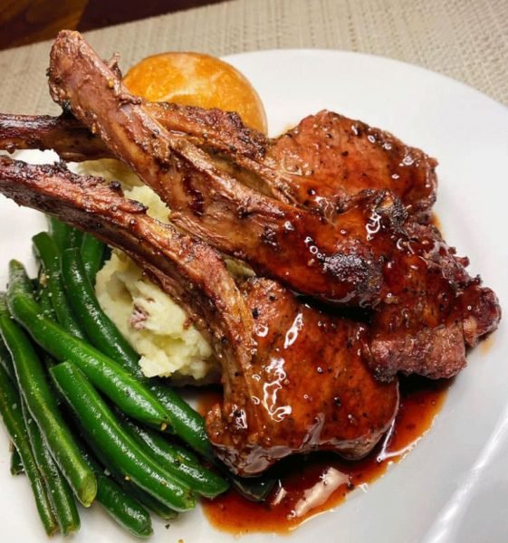 A plate of lamb chops with garlic mashed potatoes and asparagus
