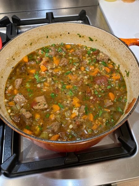 A pot of steaming hot Beef and Barley Soup on the stove