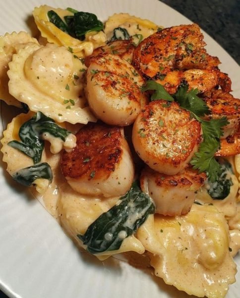 A plate of Creole Garlic Alfredo over Cheese Stuffed Tortellini with Cajun Shrimp & Scallops