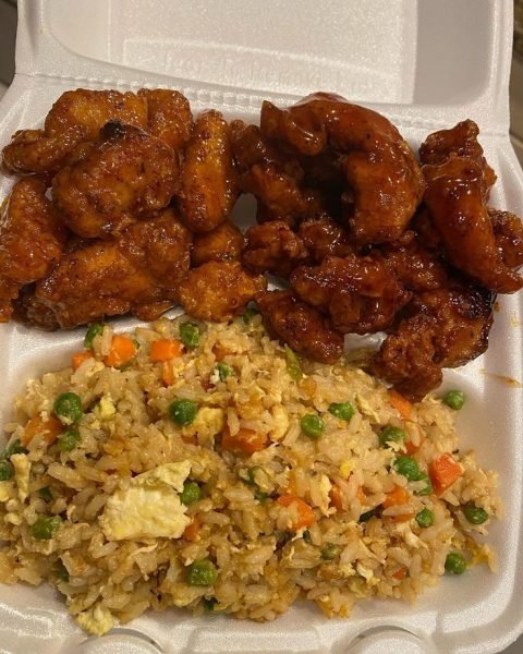 A close-up of a plate of sweet chili chicken and orange chicken with fried rice.