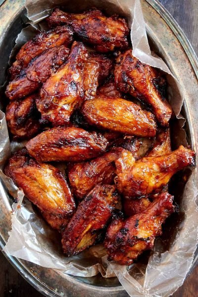 A plate of Baked BBQ Chicken Wings, crispy and golden brown, with a side of ranch dressing.