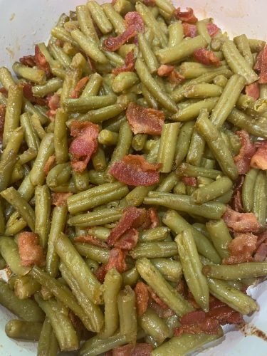 A plate of smothered green beans with bacon and onions