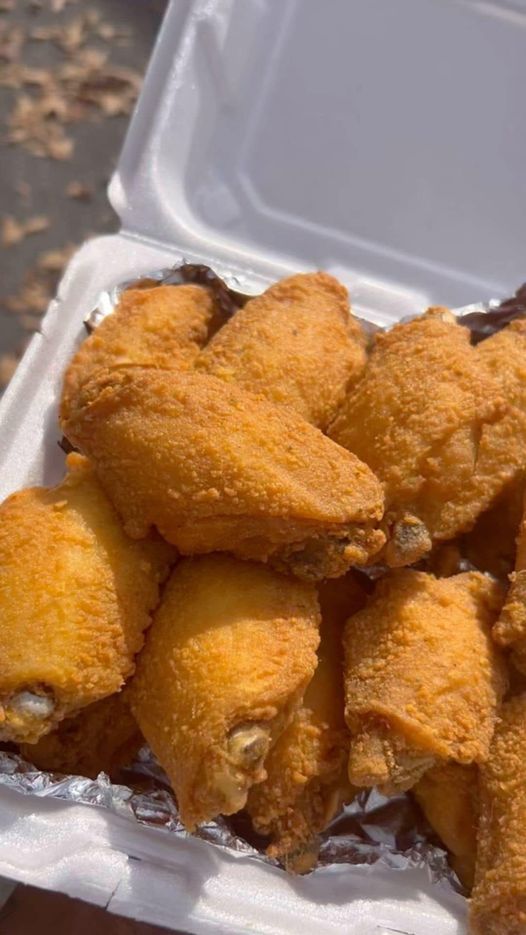 A plate overflowing with golden brown, crispy fried chicken wings.