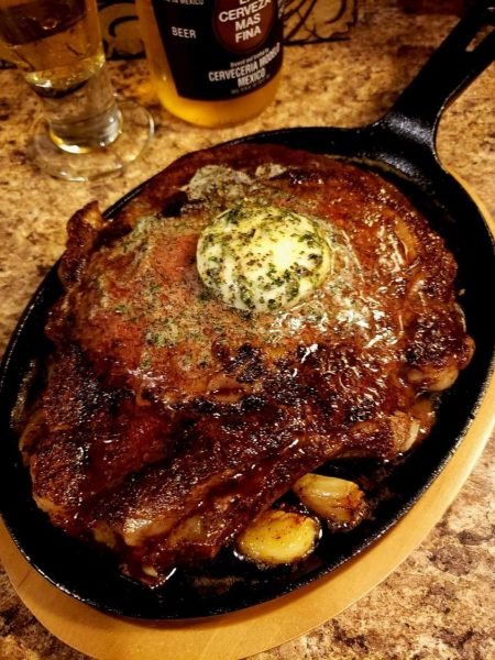Pan-seared ribeye with garlic butter on a sizzling skillet