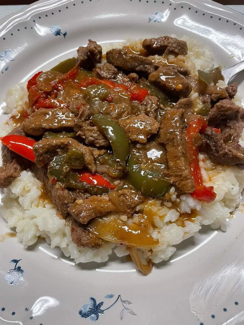 Pepper Steak over rice - A scrumptious dish of seasoned steak strips and colorful peppers served on a bed of rice.