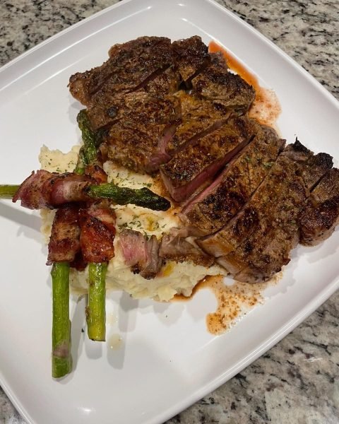 Steak with bacon wrapped asparagus and buttered mash