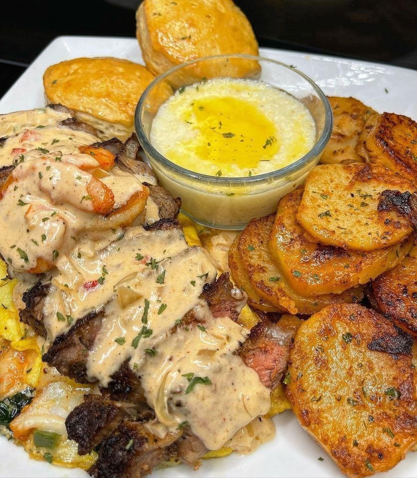 Shrimp and steak omelet, smothered onions and potatoes, grits and biscuits