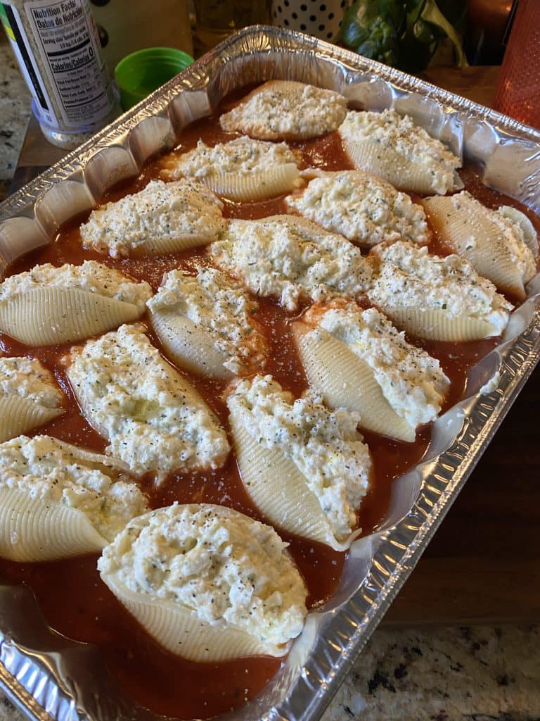 Stuffed Shells Recipe showcasing jumbo pasta shells filled with a rich blend of ricotta, mozzarella, and Parmesan, topped with melted cheese and fresh basil.