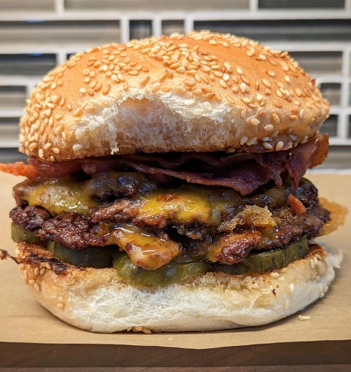 A delicious double cheeseburger on a toasted bun with toppings of lettuce, tomato, and pickles.