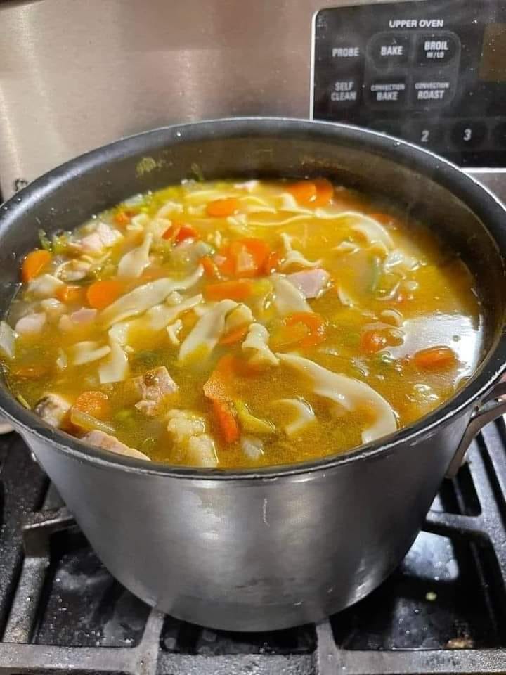 Steaming bowl of homemade chicken noodle soup - a comforting culinary delight.