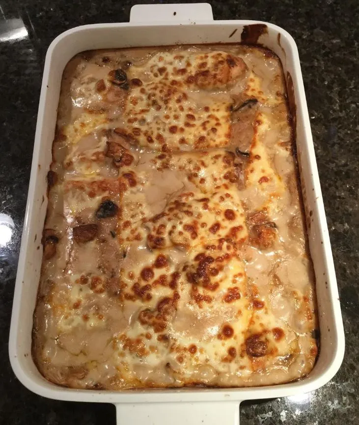 Mouthwatering photo of Chicken Gloria Casserole in a baking dish, golden brown and bubbly with melted cheese.