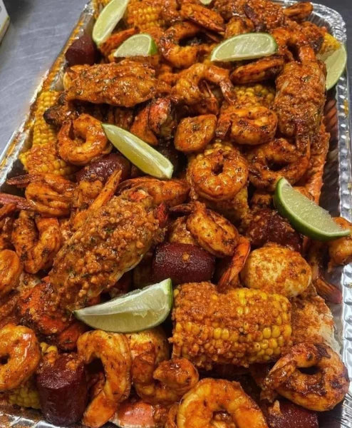 "Seafood Boil featuring fresh shrimp, crab, and lobster with Garlic Butter Sauce, served with perfectly cooked red potatoes and corn.