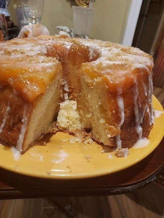 Peach Cobbler Pound Cake - A visual delight showcasing layers of cream cheese, fresh peaches, and a drizzling glaze on a bundt pan