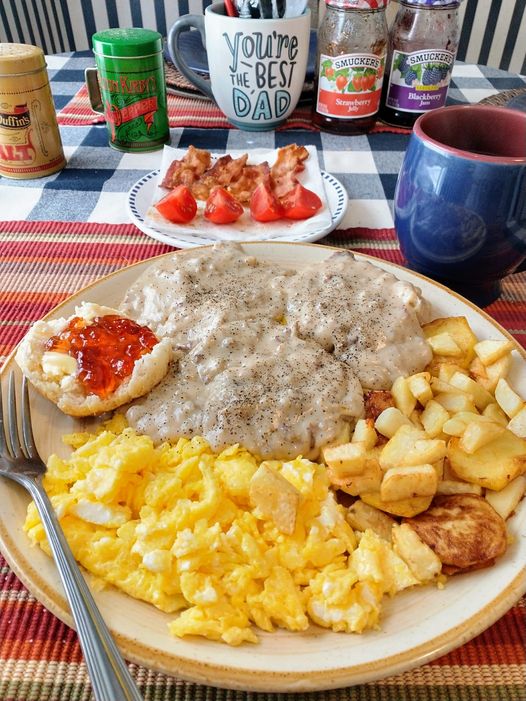 "Sausage Gravy Biscuits: A golden-brown biscuit topped with savory sausage-infused gravy on a plate."