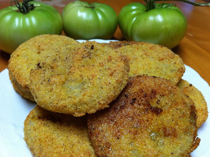 Sliced green tomatoes being prepared for frying