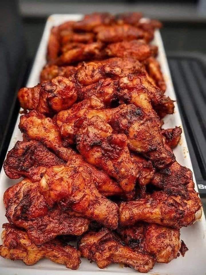 Smoked chicken wings arranged on a grill, showcasing a perfect blend of spices and a tantalizing crispy finish.