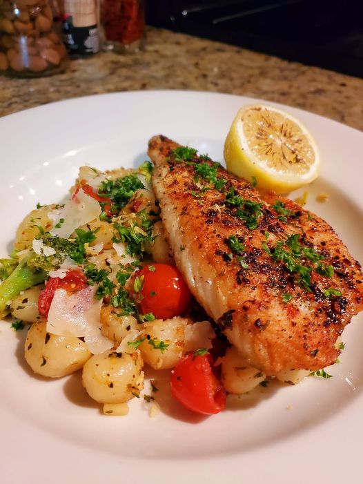 Plated Pan Seared Branzini and Gnocchi with vibrant cherry tomatoes