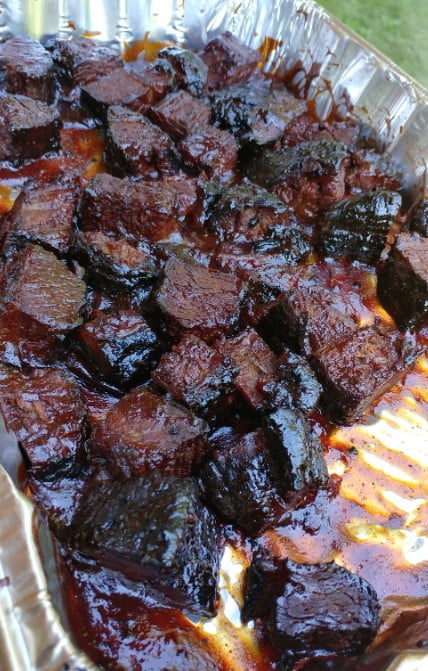 Smoked brisket burnt ends arranged on a platter, glazed to perfection.