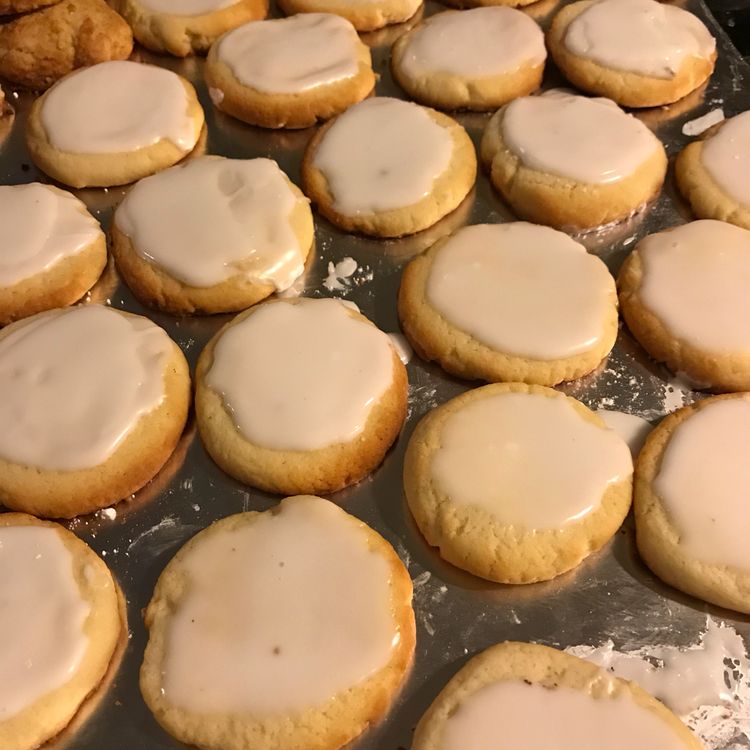 A close-up photo of almond meltaway cookies on a cooling rack. The cookies are light and airy, with a sprinkle of sliced almonds on top.