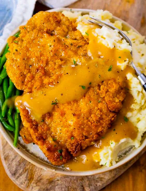 A symphony of flavors: golden fried chicken and creamy mashed potatoes on a white plate.