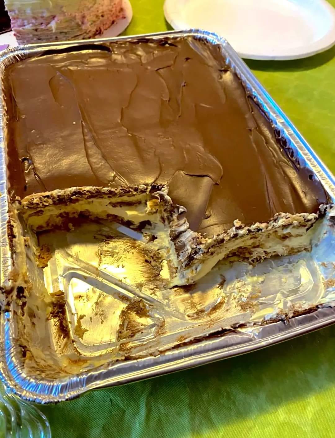 No-bake chocolate eclair cake on a plate with a chocolate drizzle.