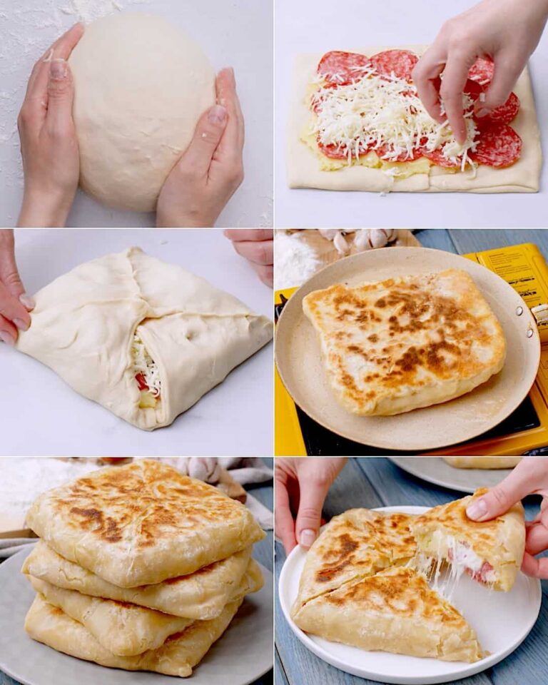 A close-up photo of two golden brown calzones on a baking sheet, filled with melted cheese and sprinkled with fresh herbs.