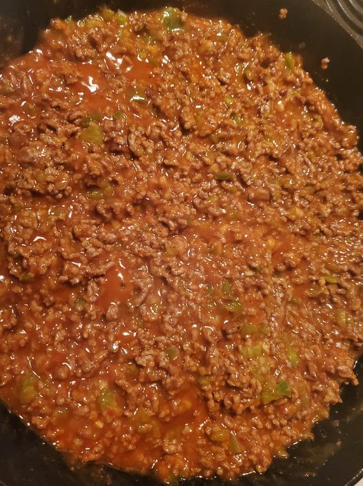 A close-up photo of a hamburger bun overflowing with a savory Sloppy Joe mixture made with ground beef, peppers, onions, and salsa.