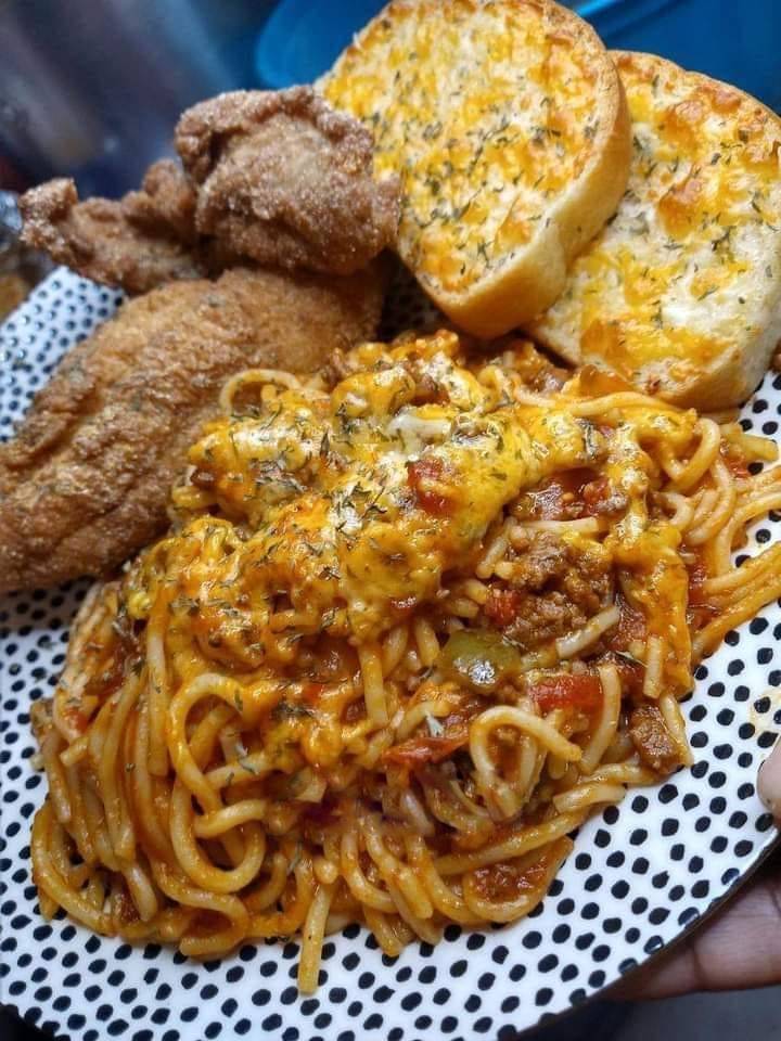 Fried catfish fillets served over spaghetti with tomato sauce